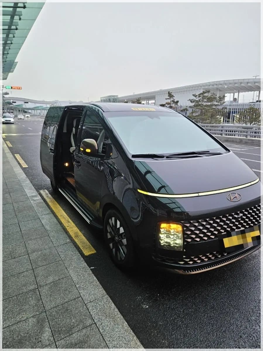 인천공항 출발층 승하차장에 문을 열고 선 검은색 스타리아